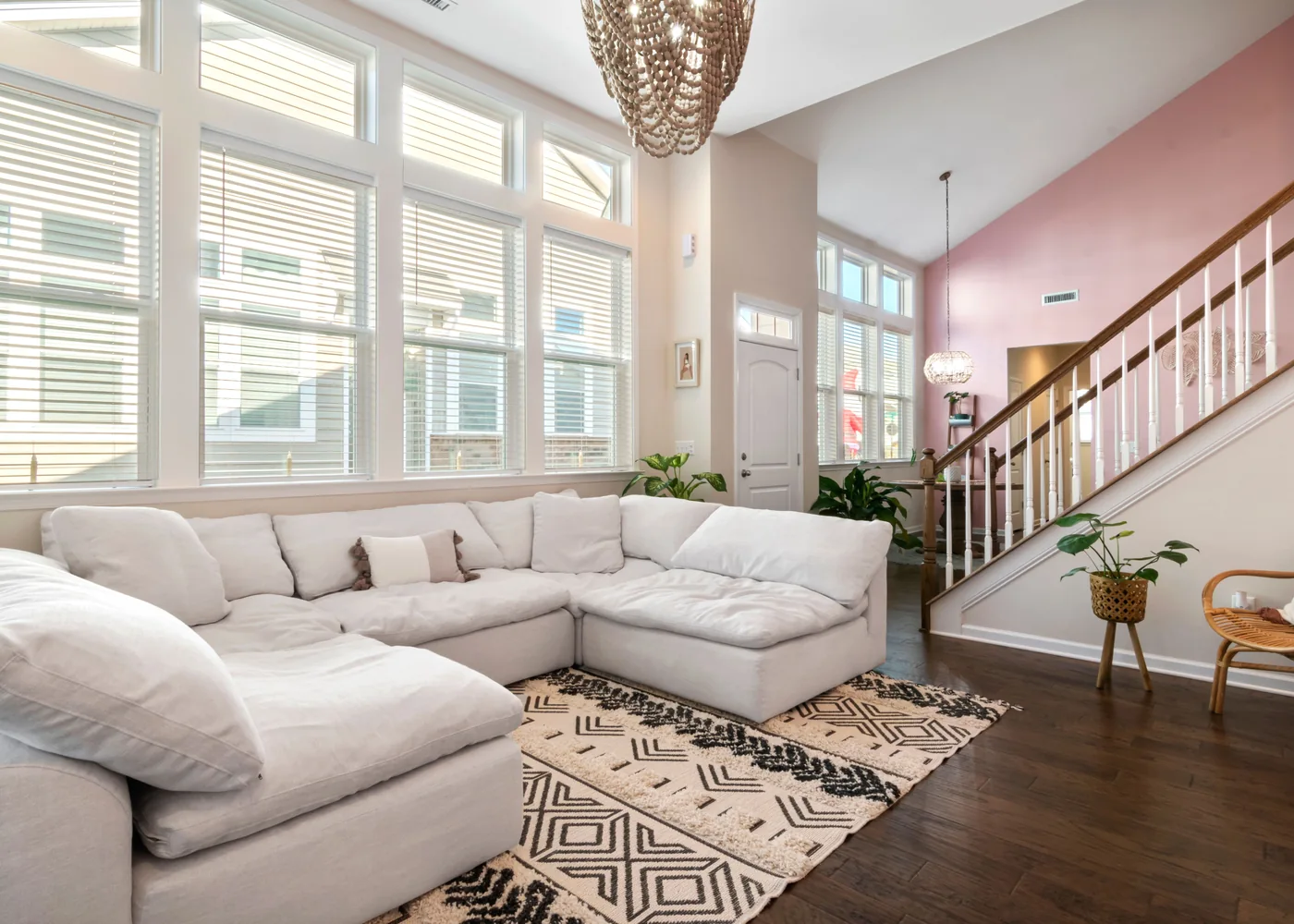 A light, inviting living room with a cream sofa, natural textures and leafy plants